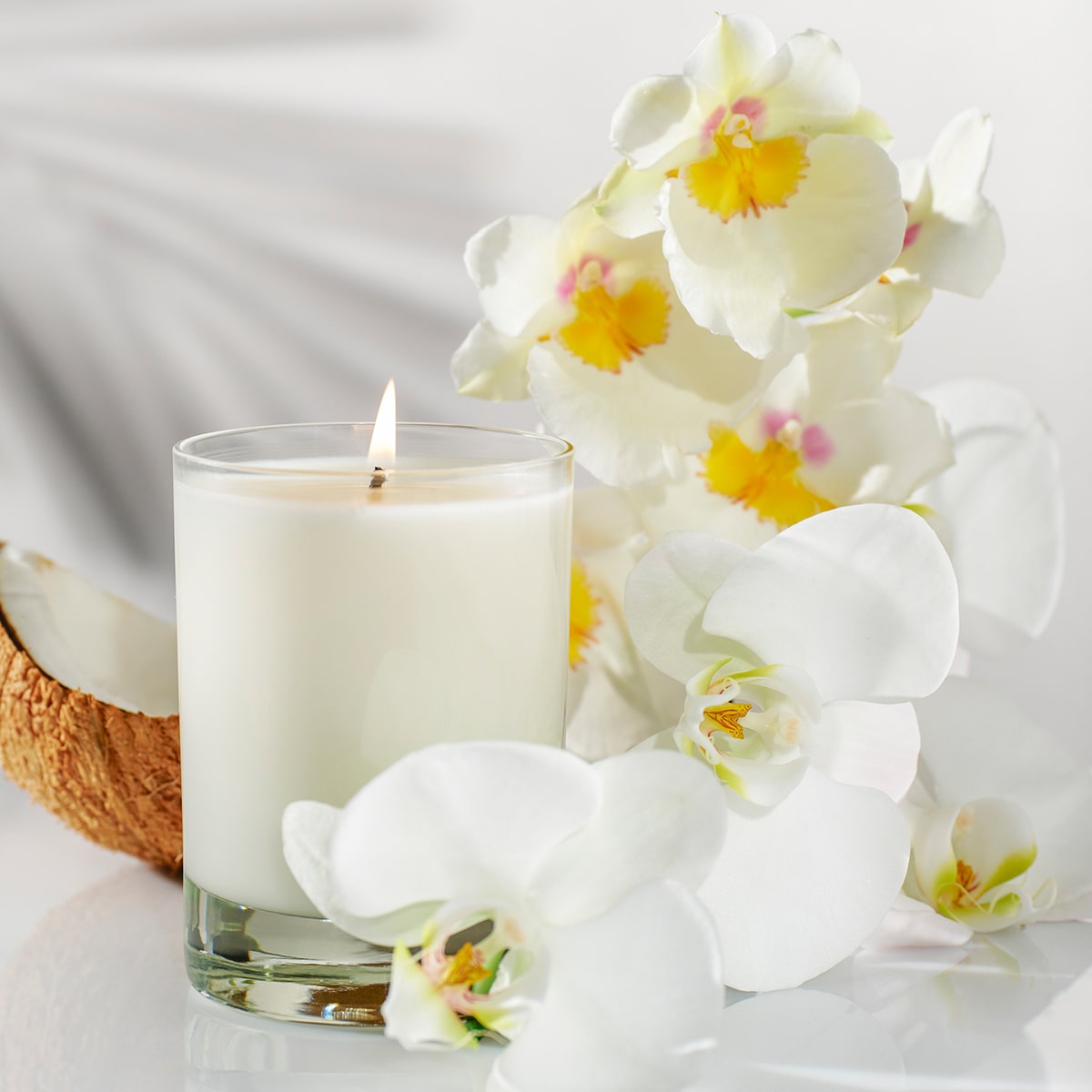 Kai Fragrance Skylight Candle (10 oz) with white and yellow flowers on a light background