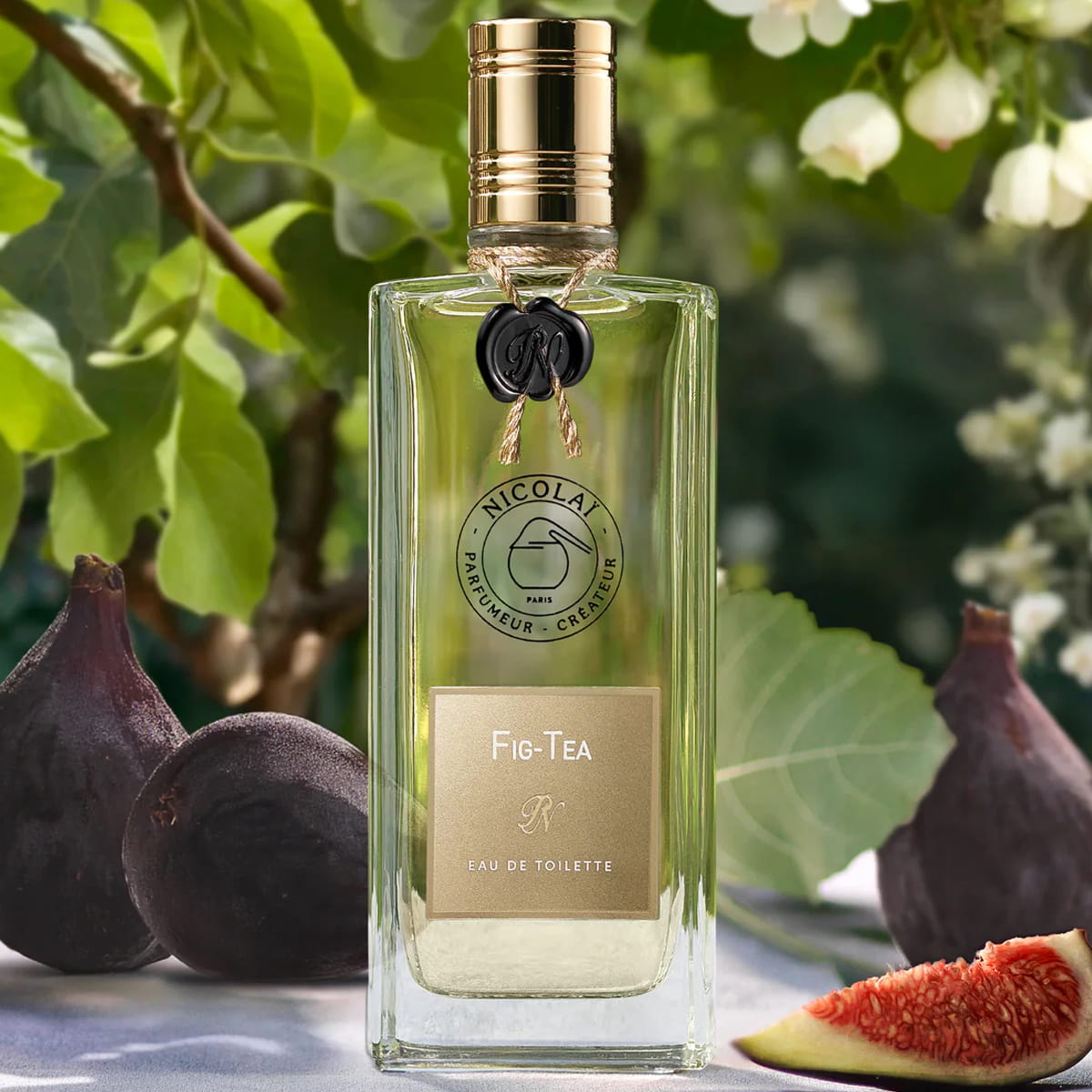 Lifestyle shot of Parfums de Nicolai Fig Tea Eau de Toilette 100 ml with figs in the background and foreground
