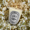 Diptyque Jasmin Candle (190 g) - product shown on top of flowers. 