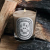 Diptyque Feu de Bois (Firewood) Candle (190 g) - product shown on top of wood. 