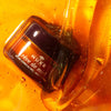 Nuxe Reve de Miel Lip Balm - Lifestyle photo of container in honey