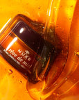Nuxe Reve de Miel Lip Balm - Lifestyle photo of container in honey