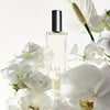 Kai Eau de Parfum Spray (1.7 oz/ 1 oz) surrounded by white flowers on a light background