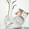 Kai Fragrance Body Butter (6.4 oz) with flowers on a light background