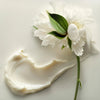 Leonor Greyl Masque Quintessence (200 ml) - product swatch shown next to flower.