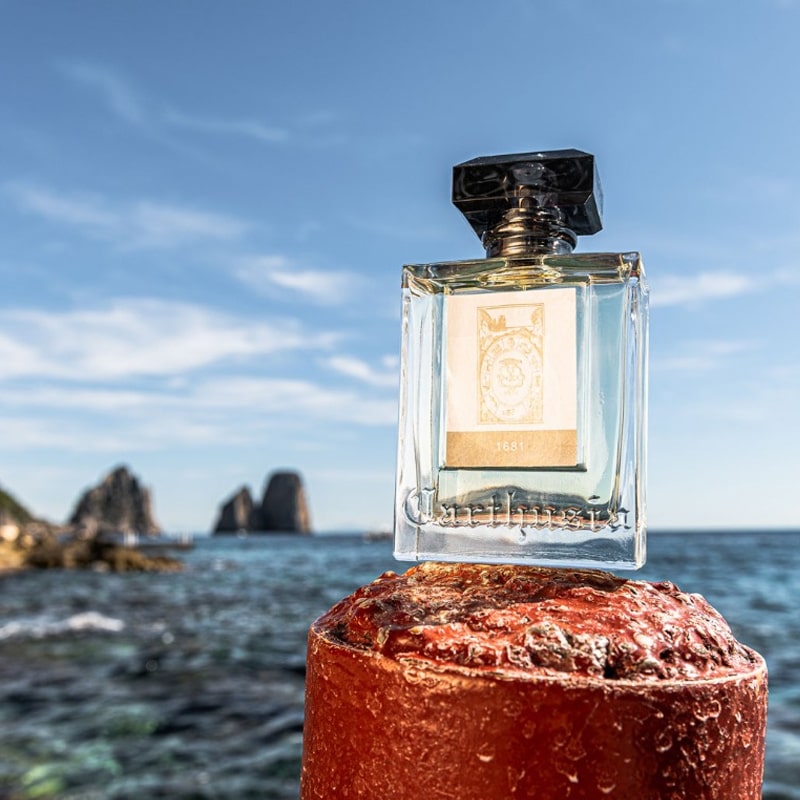 Lifestyle shot of Carthusia 1681 Eau de Parfum (100 ml) with ocean in the background