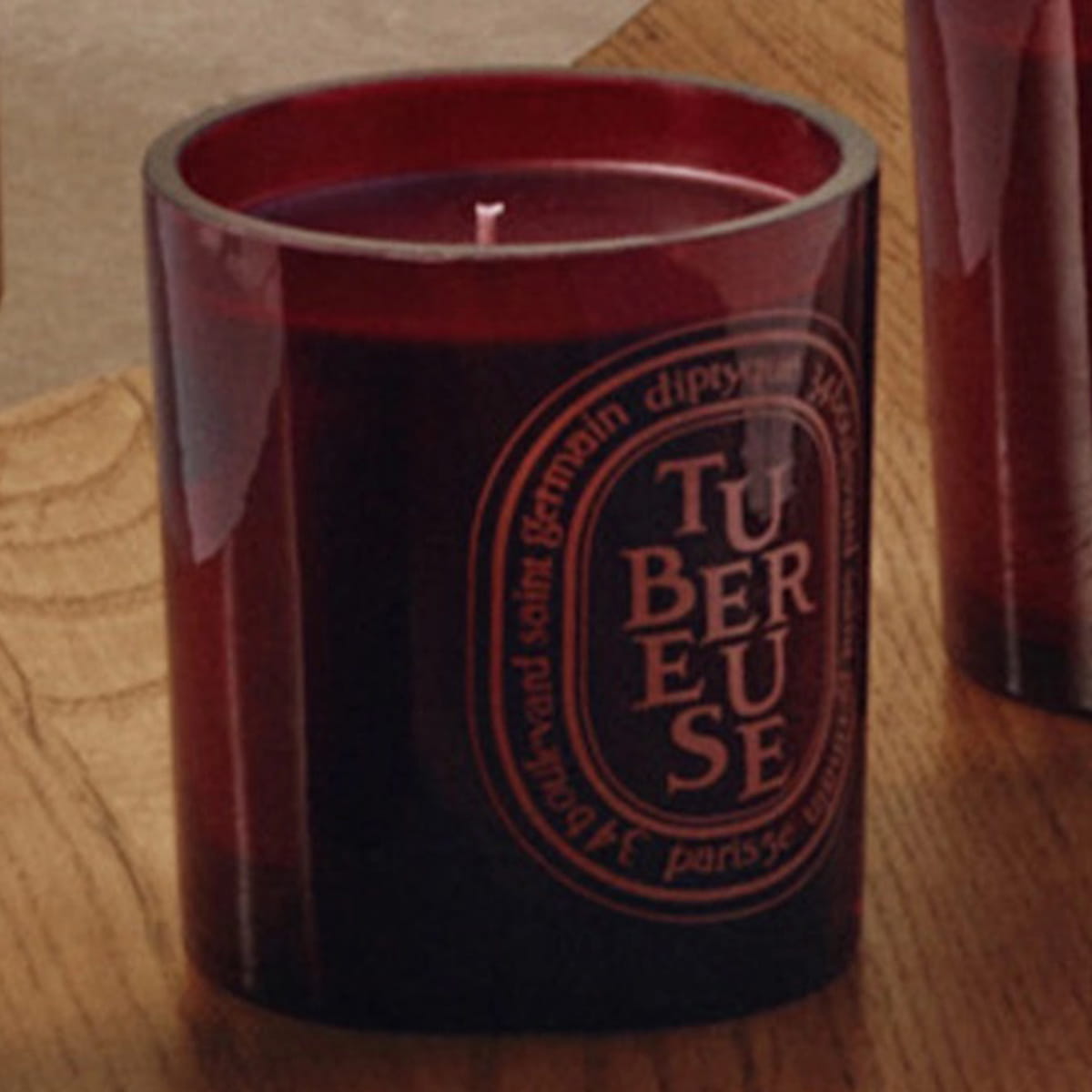 Diptyque Tubereuse Rouge Candle (300 g) - product shown on wooden counter.