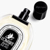 Diptyque L'Ombre Dans L'eau Eau de Toilette (100 ml) - product shown laying on side on counter.