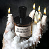 Lifestyle shot of D.S. & Durga Burning Barbershop Eau de Cologne (50 ml) sitting in model's hand with melted candle wax and lit candles on fingertips
