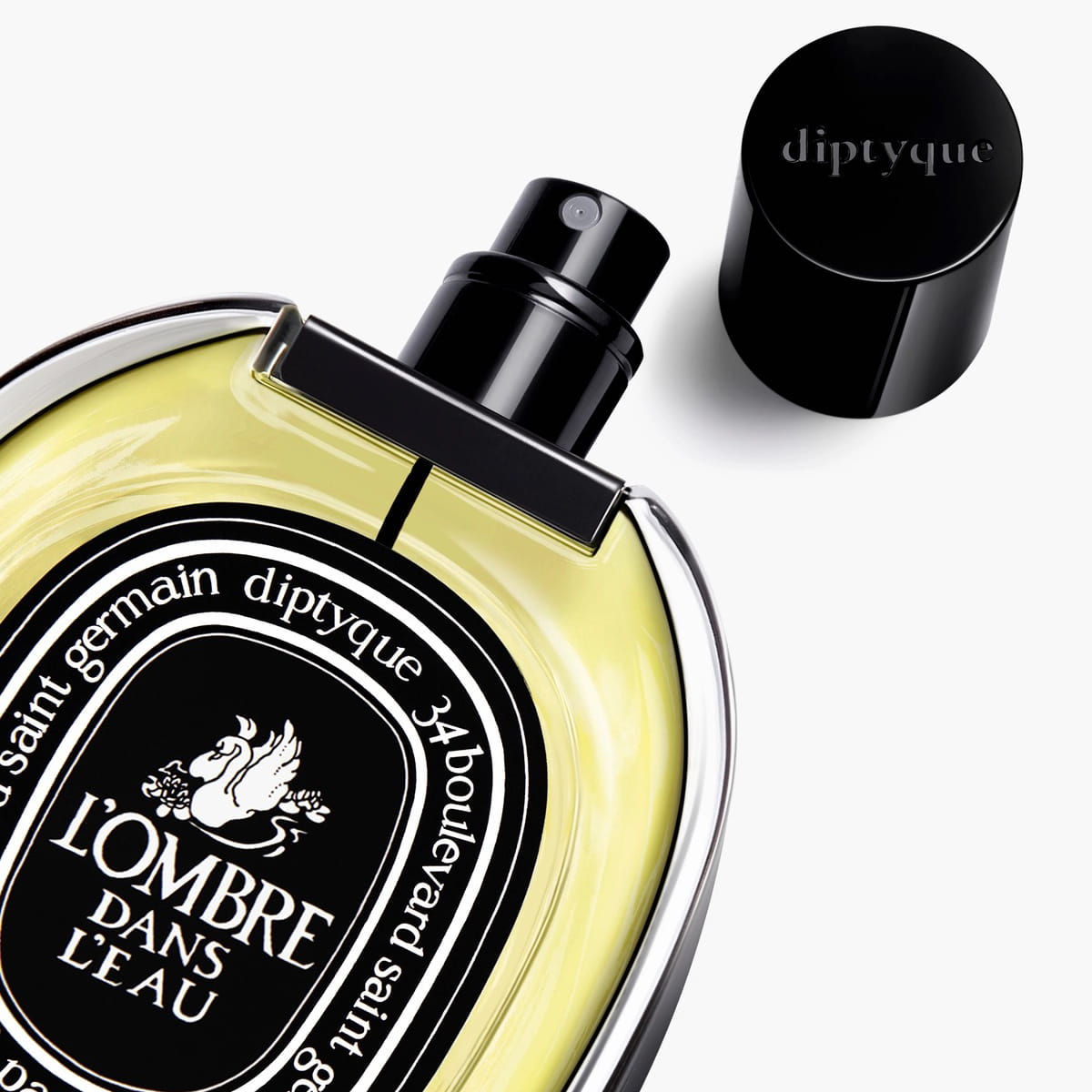 Diptyque L'Ombre Dans L'Eau Eau de Parfum (75 ml) - product shown laying on side with lid off. 