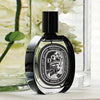 Diptyque Do Son Eau de Parfum (75 ml) - product shown in front of vases with flowers.