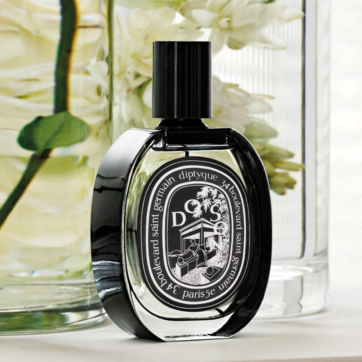 Diptyque Do Son Eau de Parfum (75 ml) - product shown in front of vases with flowers.