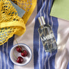 Lifestyle shot top view of Laboratory Perfumes Amber Eau de Toilette on blue and white stripe tablecloth