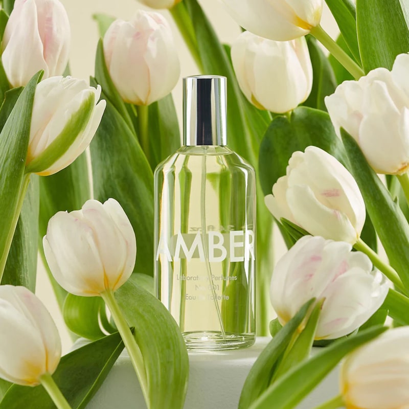 Lifestyle shot of Laboratory Perfumes Amber Eau de Toilette with pale colored tulips in the background and foreground