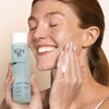 Model holding bottle of Yon-Ka Paris Gel Nettoyant (200 ml) and applying cleansing gel to face