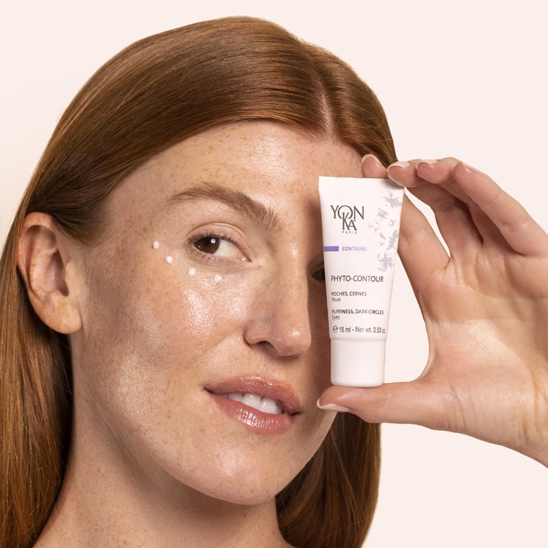 Model holding tube of Yon-Ka Paris Phyto-Contour (15 ml) and cream shown applied to under eye area