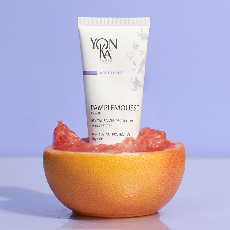 Lifestyle shot of Yon-Ka Paris Pamplemousse Creme PS for Dry Skin (50 ml) sitting inside half of a grapefruit 