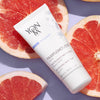 Lifestyle shot top view of Yon-Ka Paris Pamplemousse Creme PS for Dry Skin (50 ml) sitting on top of grapefruit halves