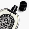 Diptyque Tam Dao Eau de Parfum spray (75 ml) - product shown laying on side with lid off.