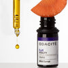 Lifestyle shot of Odacite Wild Carrot Serum Concentrate (Vitality) 0.17 oz with slice of carrot sitting on top of opened bottle