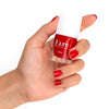 Close up of model wearing Kure Bazaar Nail Lacquer - Lipstick (10 ml) and holding bottle