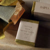 Lifestyle shot of Saipua Soaps Vetiver with French Green Clay Soap (6 oz) shown wrapped and unwrapped