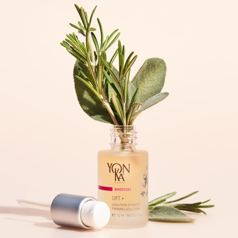Yon-Ka Paris Lift + Firming Solution (15 ml) shown with top off and ingredients including rosemary and sage placed in bottle