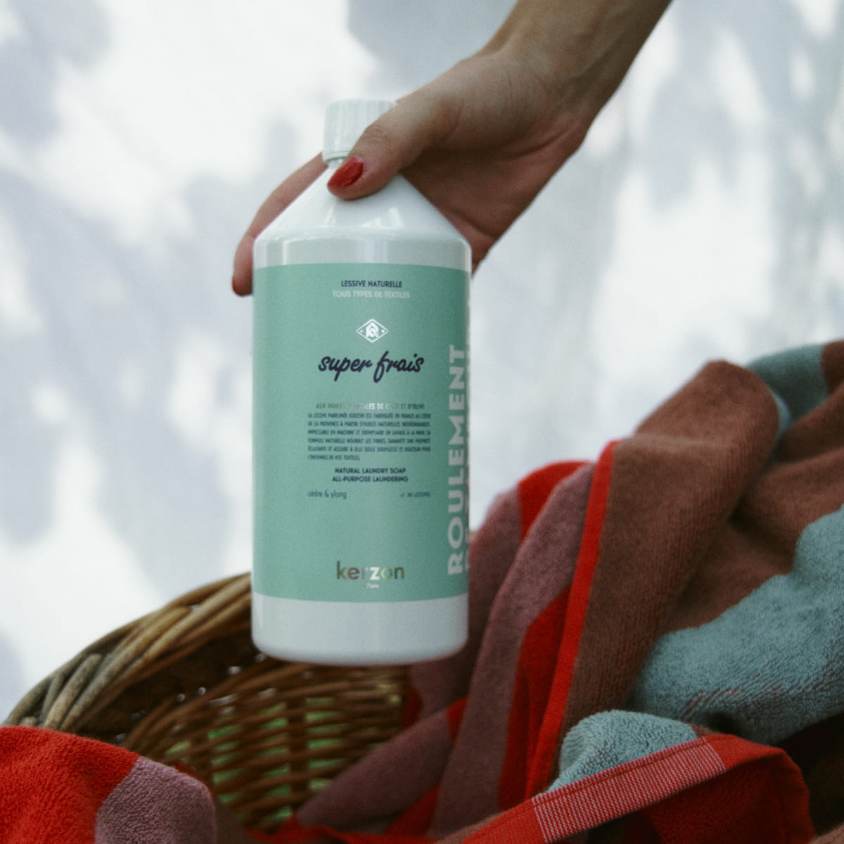 Kerzon Fragranced Laundry Soap - Super Frais (1 L) - product shown being held over linen basket. 