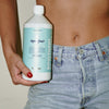Kerzon Fragranced Laundry Soap - Super Frais (1 L) - product shown being held by model in blue jeans. 