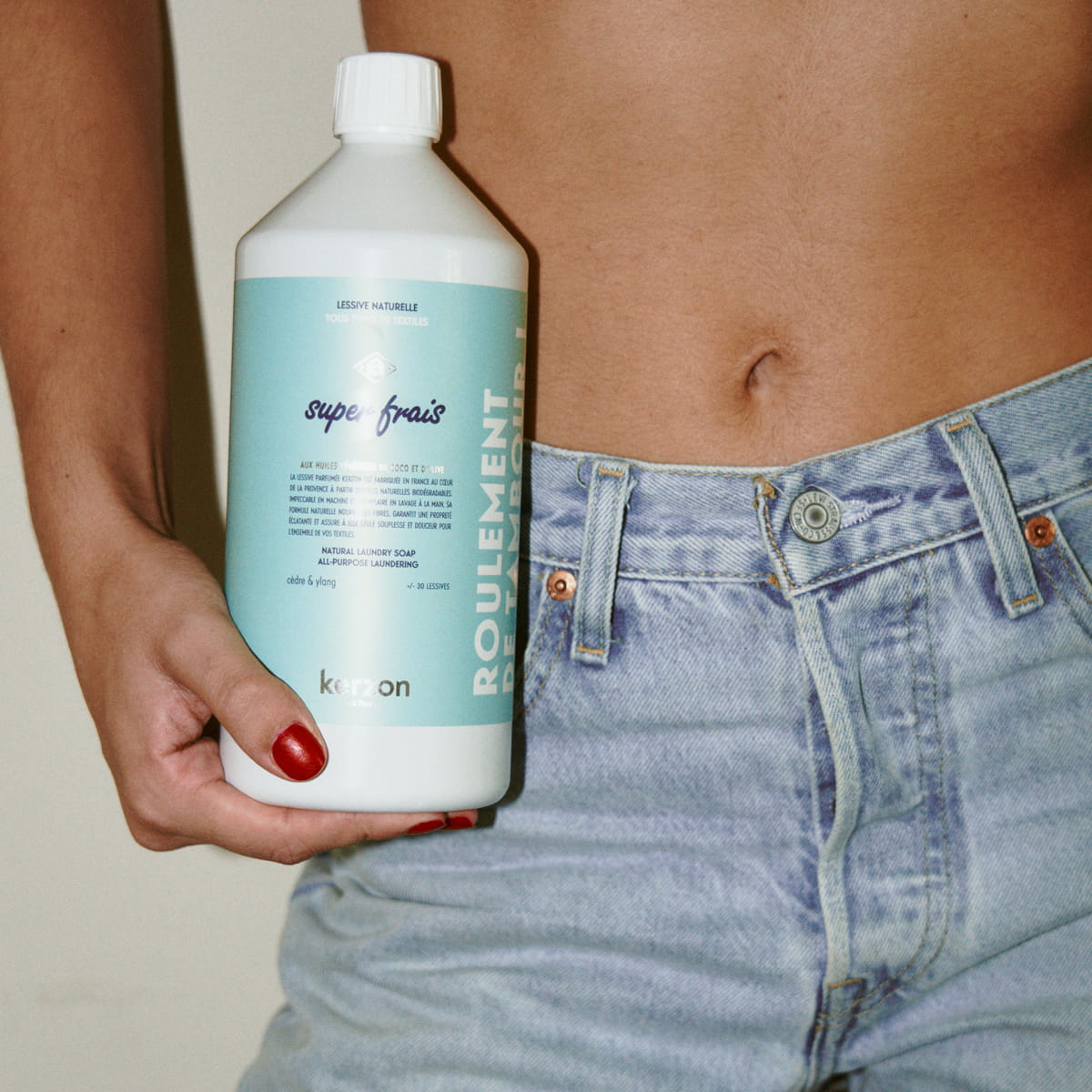 Kerzon Fragranced Laundry Soap - Super Frais (1 L) - product shown being held by model in blue jeans. 