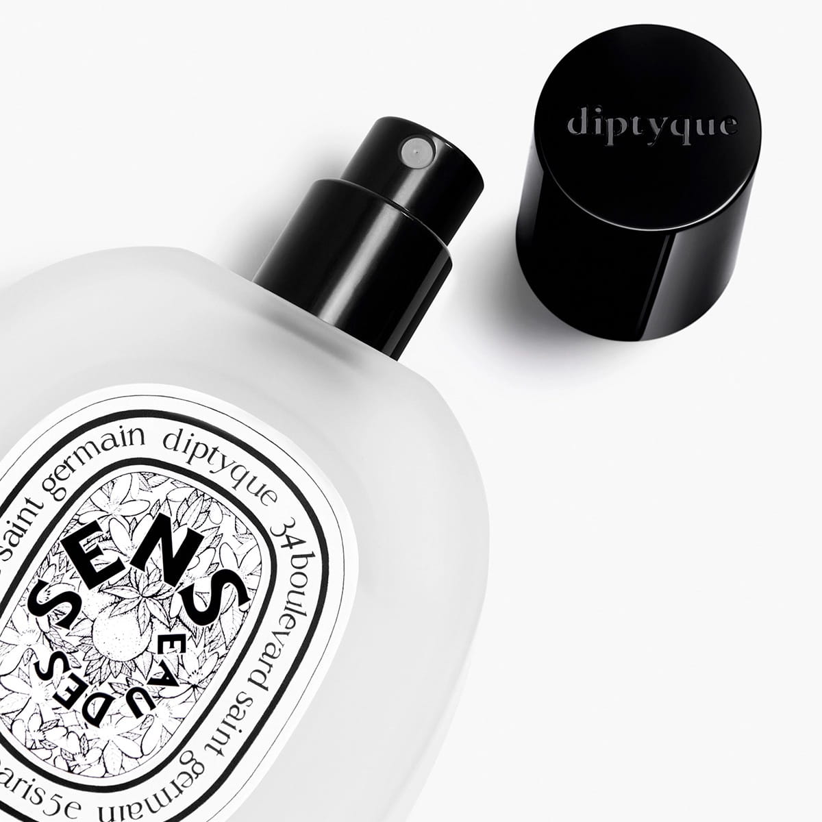 Diptyque Eau des Sens Hair Mist (30 ml) - product shown laying on side with lid off. 
