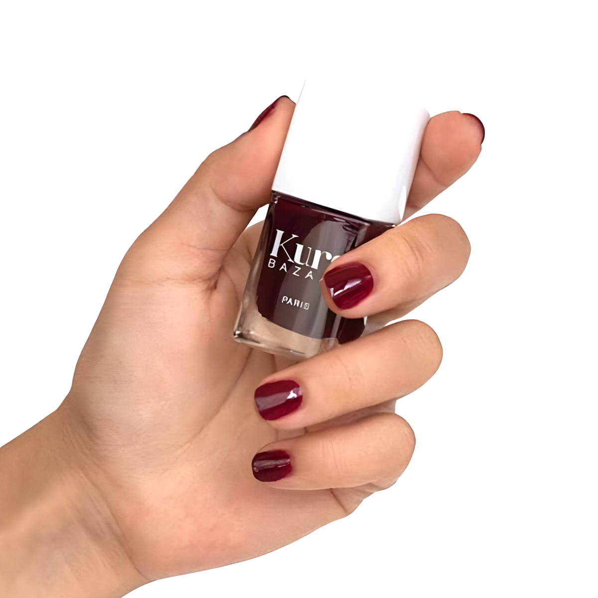 Close up of model wearing and holding bottle of Kure Bazaar Nail Lacquer - Parisienne (10 ml)