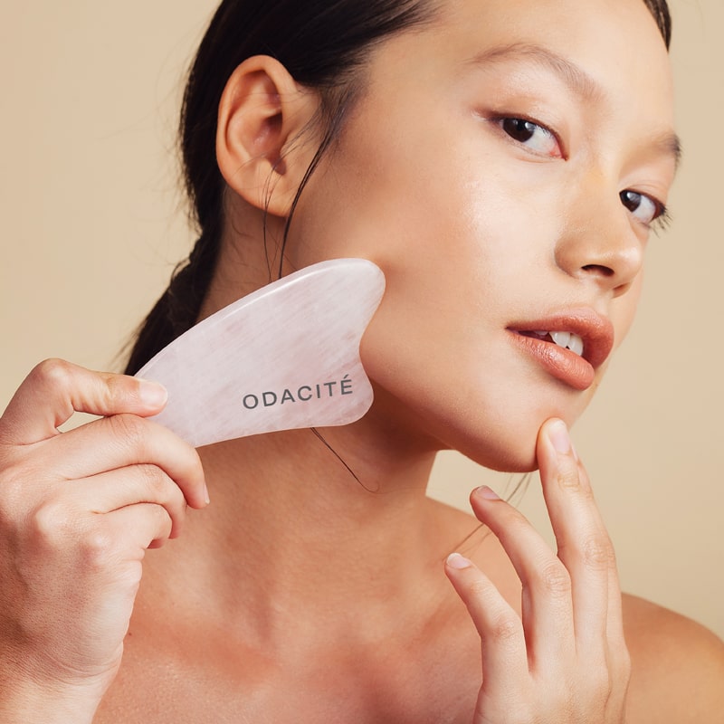 Model using the Odacite Crystal Contour Gua Sha Rose Quartz Beauty Tool