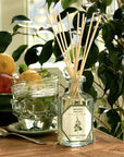 Lifestyle shot of Carriere Freres Spearmint Diffuser on table with glass of water and bowl of fruit in the background