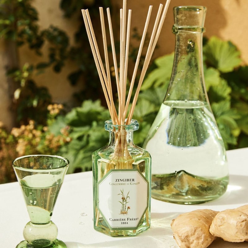 Lifestyle shot of Carriere Freres Ginger Diffuser (200 ml) with pitcher of water in the background and ginger in the foreground