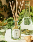 Lifestyle shot of Carriere Freres Ginger Diffuser (200 ml) with pitcher of water in the background and ginger in the foreground