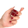 Close up of model wearing and holding bottle of Kure Bazaar Nail Lacquer - Sienna (10 ml)