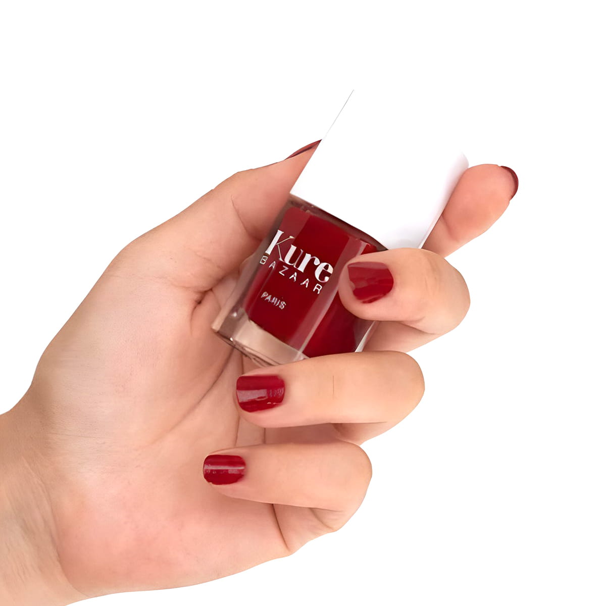 Close up of model wearing and holding bottle of Kure Bazaar Nail Lacquer - Sienna (10 ml)