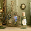 Lifestyle shot of Carriere Freres Lavender Room Spray (200 ml) with ornate painted vase in the background