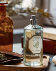 Lifestyle shot of Carriere Freres Sandalwood Room Spray (200 ml) with cap off on wood tray and books in the background