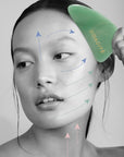 Diagram on face of model showing how to use the Odacite Crystal Contour Gua Sha Green Adventurine Beauty Tool (arrows showing direction of use and motion)