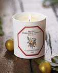 Lifestyle shot of Carriere Freres Mirabelle Candle (185 g) shown lit with mirabelle plums in the background and foreground