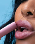 Close up of model applying Kosas Cosmetics Kosasport LipFuel - Rush (5 g) to lips