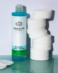 Odacite Blue Aura Cleansing Water (4 oz) shown with top off and stack of cotton pads next to the bottle