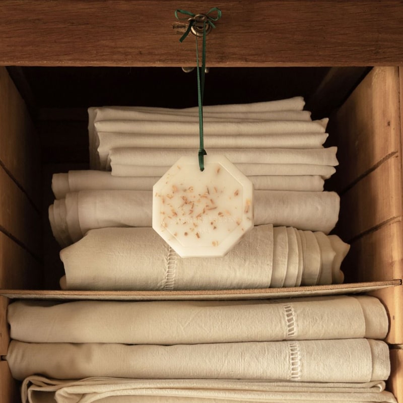 Lifestyle shot of Carriere Freres Cedar Botanical Palet shown hanging in linen storage