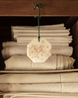 Lifestyle shot of Carriere Freres Cedar Botanical Palet shown hanging in linen storage