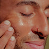 Close up shot of model applying Bathing Culture Outer Being Face & Body Oil to face
