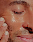 Close up shot of model applying Bathing Culture Outer Being Face & Body Oil to face