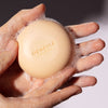 Close up of Odacite 552M Shampoo Bar with suds in hands of model