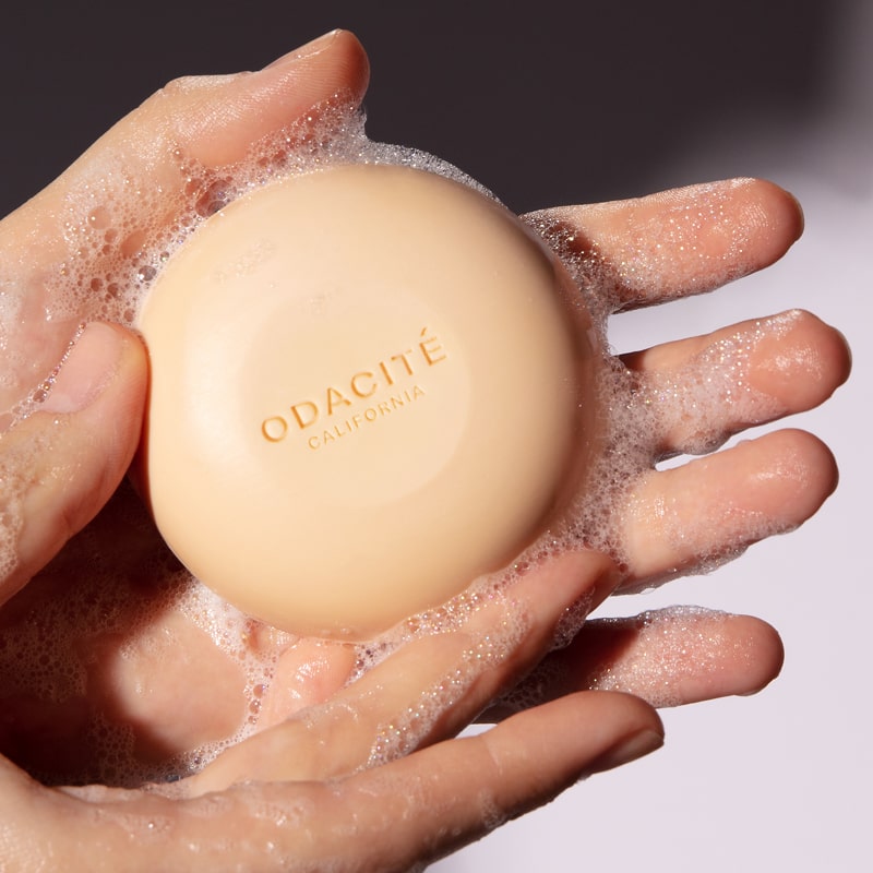 Close up of Odacite 552M Shampoo Bar with suds in hands of model